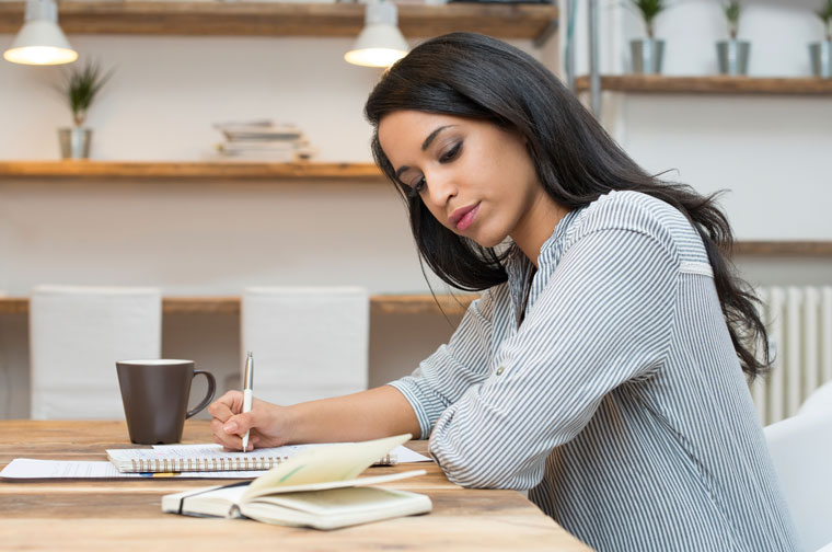 Woman writing at desk.